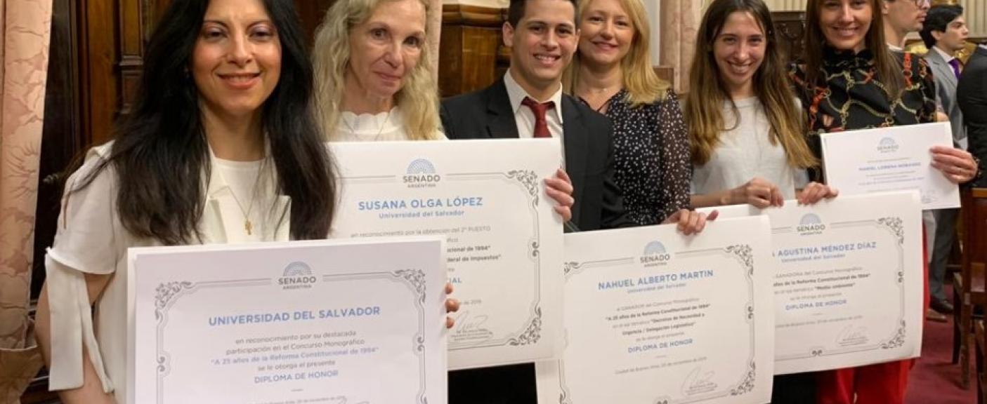 Autoridades de la Facultad de Ciencias Jurídicas con los alumnos homenajeados.